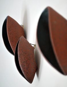 three pieces of wood sitting on top of a white wall