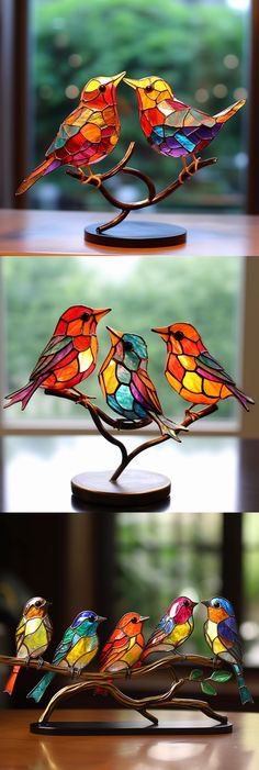 three colorful stained glass birds sitting on top of a metal stand next to each other