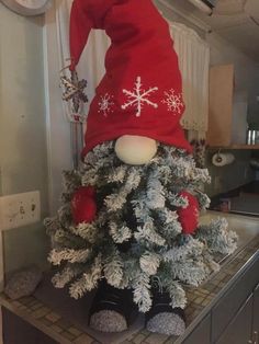 a christmas tree with a gnome's hat on top and snowflakes all over it