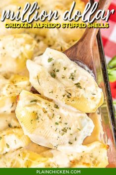 chicken alfredo stuffed shells in a casserole dish with a wooden spoon on the side