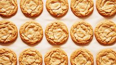 many cookies are arranged in rows on a white surface with one cookie missing the middle