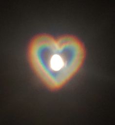 a heart - shaped object in the dark sky with a bright light coming from it