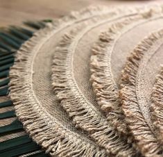 several pieces of woven fabric laid on top of each other with fringes in the middle