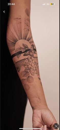 a person with a tattoo on their arm is holding something in the other hand and looking at it