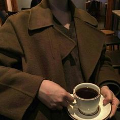 a man holding a coffee cup and saucer