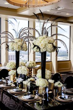 a dining room table set with black and white centerpieces