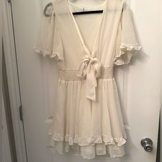 New Without Tags, Never Worn In Perfect Condition! Size Large, A Very Nice Cream Color, Not Pure White And Almost Has A Yellow Tint. Ties At The Bar Area And Adjustable! Stretchy Waistline And Flowy Sleeves And Bottom. Cream V-neck Sundress, Cream V-neck Sundress For Day Out, Off-white V-neck Sundress, Off-white V-neck Mini Dress With Ruffles, Cream V-neck Sundress For Brunch, Off White V-neck Mini Dress With Ruffles, V-neck Ruffled Sundress For Daytime, Cream V-neck Dresses For Daytime, Off White Flowy V-neck Mini Dress