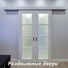 an empty room with two glass doors and wood floors