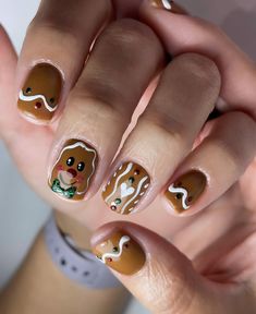 This cute gingerbread-themed nail design features a warm brown base with playful gingerbread faces and festive details. The simple short gel style keeps it practical while the holiday art makes it festive. Ideal for anyone who loves a whimsical and cozy holiday trend. Christmas Nail Gingerbread, Gingerbread Man Nail Art, Gingerbread Nail Art, Man Nail Art, Gingerbread Faces, Gingerbread Nails, Winter Nail Trends, Winter Nail Ideas, Short Gel Nails