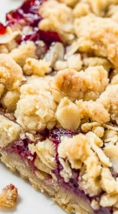 a close up of a piece of pie on a plate with crumbled toppings