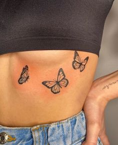 a woman's stomach with three butterflies tattooed on her lower body and the bottom part of her stomach