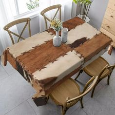 a wooden table with two vases on top of it next to chairs and a dresser