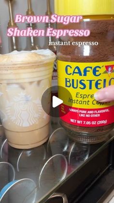 a cup of coffee sitting on top of a stove next to a jar of coffee