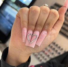 a woman's hand with pink and white nail designs on it, holding up her fingers