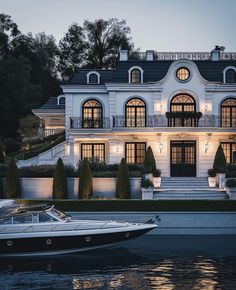 a boat is parked in front of a large white house