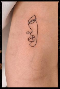 a woman's thigh with a line drawing of a face on the lower leg