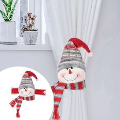 a stuffed snowman wearing a santa hat and scarf next to a potted plant