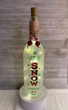 a lighted bottle that says let it snow