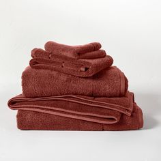 a stack of red towels folded on top of eachother in front of a white background