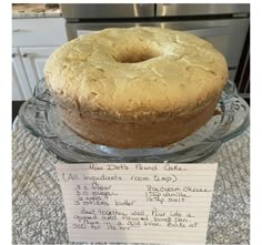 a cake sitting on top of a glass platter next to a sign that says, what do you mean?