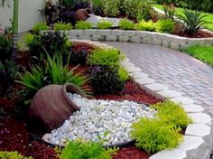 a garden with various plants and rocks in the center, along with a walkway leading up to it