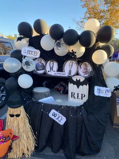 a table with balloons and decorations on it for halloween party in front of a car