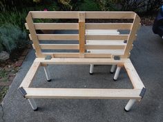 a wooden bench sitting on top of a sidewalk