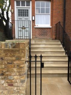 an entrance to a brick building with wrought iron railings and steps leading up to the door