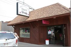 there is a small shop that has pink signs on the front and side of it