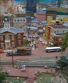 an aerial view of a model town with trains and people