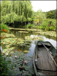 a small boat floating on top of a lake filled with water lillies and lily pads