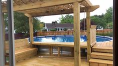 a wooden deck with a hot tub in the middle and steps leading up to it