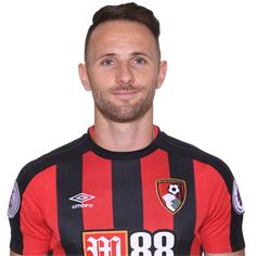 a man in a black and red shirt is posing for the camera with his hands on his hips