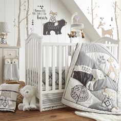 a baby crib in the corner of a room with white walls and wooden floors