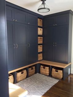 a room with blue cabinets and baskets on the floor