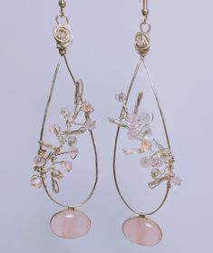 Exquisite Rose Quartz set in silver and strug on a handmade tarnish resistant,silver plated, copper wire teardrop hoop with hand made bead vine sachets through the drop made with rose quartz and glass beads on silver wire for maximum sparkle and a wire rose with a rose quartz center on top and hung from French hooks Pink Wire Wrapped Teardrop Earrings, Handmade Pink Drop Jewelry, Bohemian Teardrop Silver Plated Wire Jewelry, Bohemian Teardrop Silver Plated Jewelry, Hand Wrapped Dangle Jewelry In Silver Plated Wire, Elegant Freeform Wire Wrapped Jewelry, Hand Wrapped Silver Plated Dangle Jewelry, Rose Gold Dangling Beads Earrings As Gift, Rose Gold Dangling Beads Earrings For Gift