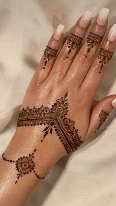 a woman's hand with henna tattoos on it