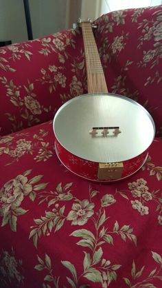 a red and white guitar sitting on top of a floral print couch cushioned area