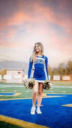 a cheerleader is standing on the football field