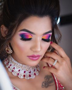 a woman with bright makeup and jewelry on her face