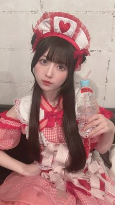 a woman in a red and white dress holding a water bottle with a heart on it