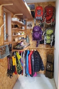 there is a closet with many coats and backpacks on the shelves next to it