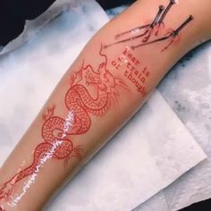 a tattoo on the arm of a woman with scissors and a dragon drawn on it