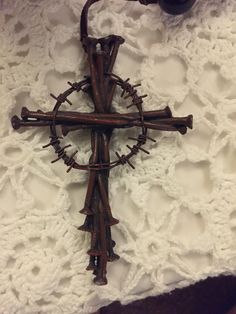 a crucifix made out of barbed wire on top of a white blanket