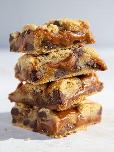 chocolate chip cookie bars stacked on top of each other with caramel drizzle