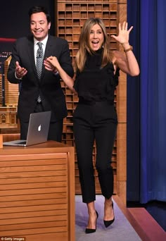 an image of a man and woman on the tonight show with their hands in the air