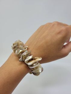 "Natural Sea Shell Bracelet. Puka Shell Bracelet - Stretch bracelet. This Seashell Bracelet is stretch. Beach Bracelet, Surfer Style. Hawaiian Design. This Shell Bracelet is perfect for Womens or Teens Handmade with 3/4\" Inch\" Hand-Selected High Quality Clam Shells. Fits Most Size. Stretch from 5\" Inches up to 6\" Inches. Around the wrist. FAST & FREE SHIPPING! Visit my Etsy Shop to see more Designs! Handmade Puka Necklaces, Bracelets and Earrings: https://www.etsy.com/shop/FreedomLifeSty Adjustable Gold Shell-shaped Bracelet, Elegant Adjustable Stretch Bracelet For Beach, Gold Shell Strand Bracelets, Elegant Adjustable Shell Bracelet, Gold Shell Beaded Bracelets As Gift, White Shell Bracelets As A Gift, White Shell Bracelets Perfect For Gifts, White Shell Oyster Bracelet, Adjustable Oyster Charm Bracelet For Beach