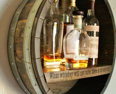 several bottles of alcohol are sitting on a wooden barrel