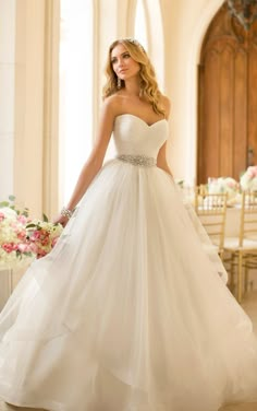 a woman in a white wedding dress is posing for the camera