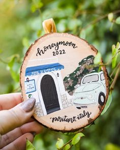 someone holding up a wooden ornament with an image of a car on it